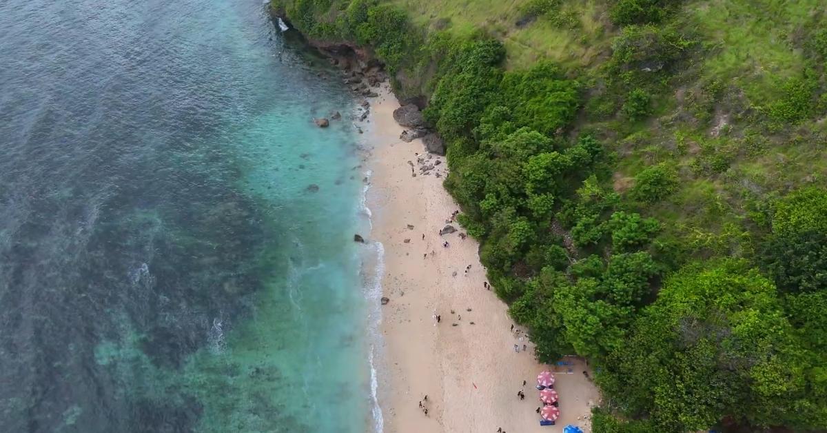 Pemandangan tebing dan laut biru di Pantai Gunung Payung