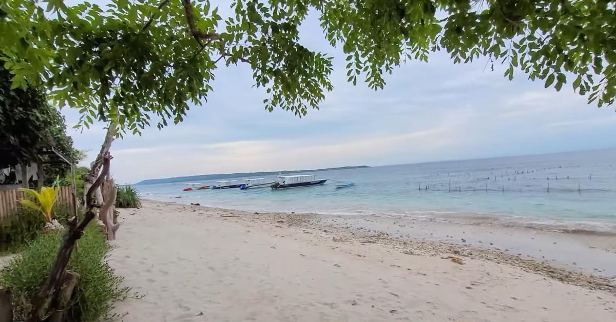 Panorama Pantai Pasir Putih dengan perahu nelayan tradisional